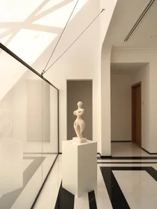 Modern, minimalist lobby with marble flooring and glass walls.