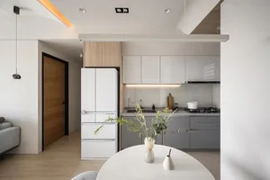 A modern kitchen with white cabinets and grey countertops.