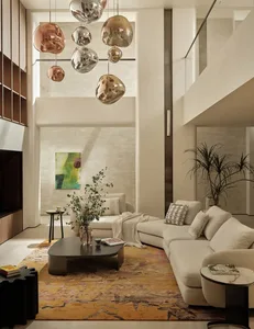 Modern living room with fabric furniture, abstract wall art, and statement pendant lights.