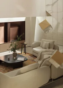 A modern living room featuring a beige couch with textured fabric, a dark wooden coffee table with a vase, and a wall-mounted