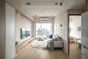 A modern living space with white painted walls and a large window overlooking a cityscape.