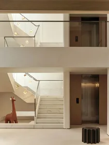 Modern lobby interior with marble stairs and pendant lights.