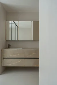 Modern bathroom with white marble countertops, a white sink, and a mirror above