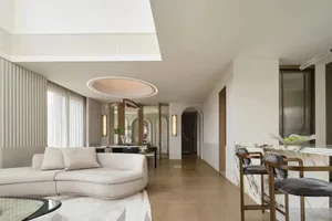 A modern living room featuring marble, wood, and glass materials with a minimalist design.