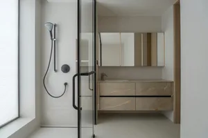Modern minimalist bathroom featuring a marble countertop and vanity, glass walk-in shower enclosure, and a large mirror above