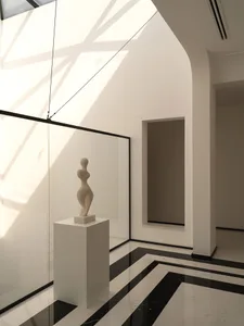 Sculpture in a modern exhibition room made of marble and concrete materials.