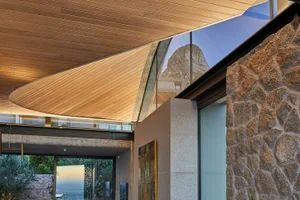 Modern residential interior featuring wood, glass, concrete, and stone materials