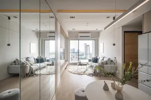 A modern living room featuring comfortable sofas, soft cushions, and minimalistic decor.