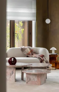 A modern living room featuring marble and glass furniture.