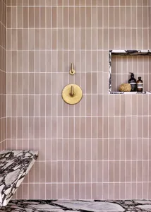 A modern bathroom featuring tiles on the walls and floor.