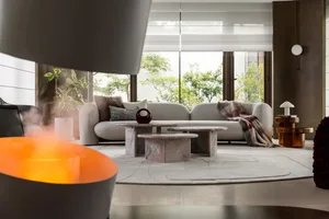 Contemporary living room with white sofa, coffee tables, and a cozy blanket on the couch.