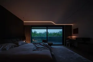 A modern bedroom featuring wooden furniture and a view of the outdoors.