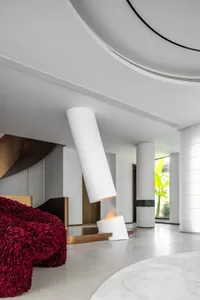 A modern living room featuring concrete, metal, and glass materials.
