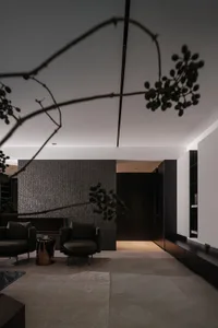 A modern living room featuring dark metallic texture walls and minimalist black seating.