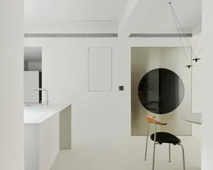 Modern minimalist kitchen with sleek white cabinets, glass backsplash, and metallic accents.
