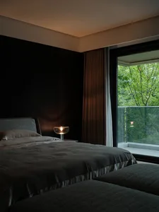 A modern bedroom featuring a textured accent wall and a soft, inviting bed.