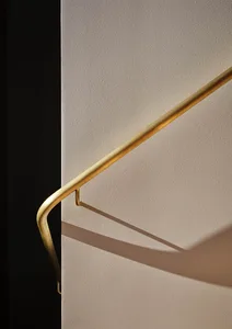 A metallic handrail with a lighting shadow in an interior design setting.