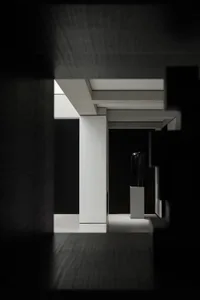 A minimalist interior with black and white elements, featuring concrete walls and a black sculpture.