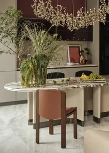 A modern kitchen with a white marble backsplash, featuring a variety of green plants, and a contemporary table with fruit.