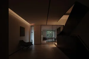 Minimalistic modern living room with wooden flooring and furniture.