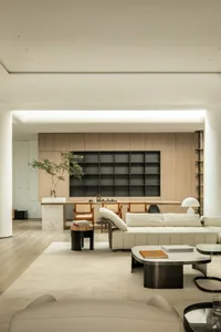 A modern minimalist living room featuring leather furniture, marble surfaces, and monochrome decor.