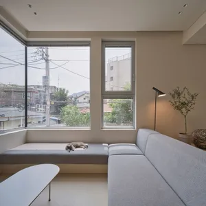 A modern, minimalist living room with neutral colors, featuring a comfortable seating area and a coffee table.
