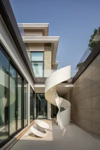 Modern residential architecture featuring concrete, glass, and stone materials.