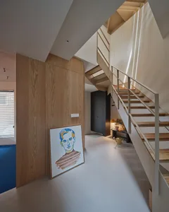 A modern staircase with wooden stairs and railings in an interior setting.