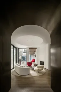 Modern living room with white marble floor, red accent chair, and white sofa.