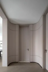 Modern entry way with curved panel closet doors and curved ceiling.