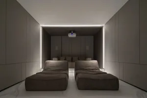 A modern home theater with fabric seats, featuring a minimalist design and ambient lighting.