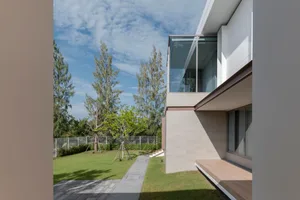 A modern house exterior featuring glass and concrete materials.