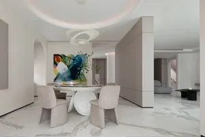 A modern living room with marble floors, a marble table, and marble countertops, featuring contemporary furniture and a minim
