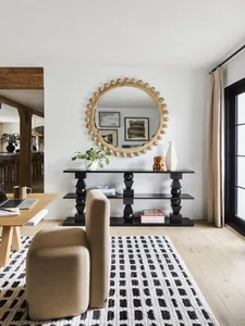 A modern living room featuring wooden furniture, fabric seating, and metal decor.