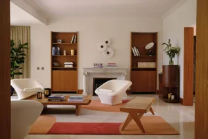 A modern living room featuring wood furniture, a fireplace, and a colorful rug.