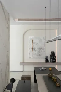 A modern interior design featuring a marble and concrete wall in a living and dining room setting.