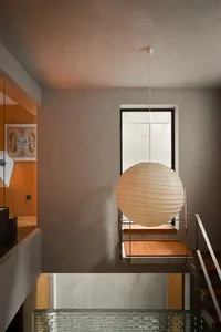 A minimalist interior with wooden elements and a spherical lamp hanging from the ceiling.