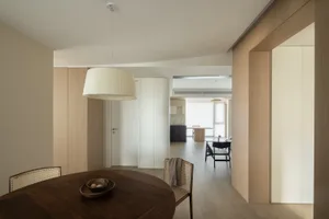 Modern open-plan dining kitchen with wooden furniture and minimalist design.