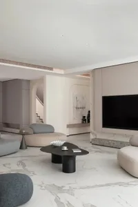 A modern residential living room with marble floors and comfortable seating options.