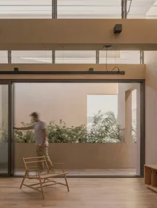 A modern residential room with wooden flooring and a large glass window.