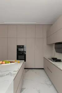 A modern kitchen with minimalist design featuring marble countertops and cabinets, sleek and clean lines.