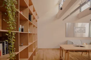 Minimalist living room with wooden shelves, a table, and a world map on the wall.