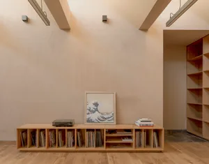 A minimalist living room featuring wooden shelves and a wooden floor.