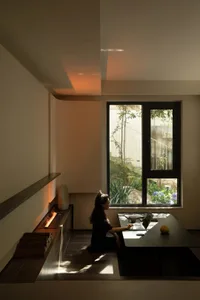 A minimalist residential interior with an open floor plan, a large window, and a modern fireplace.