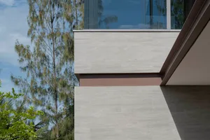 Modern home exterior featuring a tile wall and large windows.