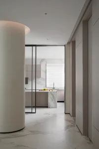 Modern kitchen interior featuring marble countertops and a large island.