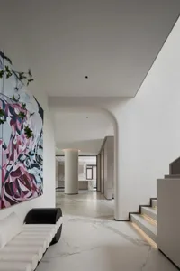 A modern living room featuring marble flooring and a large abstract painting on the wall.