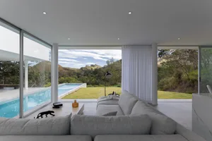 Modern white-painted interior with furniture and a view of a spa pool.