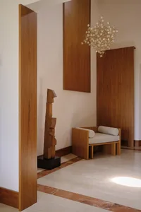 Modern living room featuring wooden furniture and a wooden sculpture.