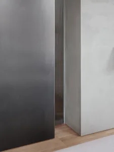 A modern minimalist bedroom with concrete walls and flooring.